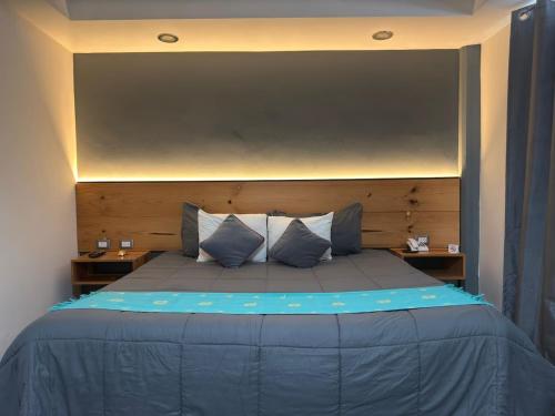 a bedroom with a large bed with blue sheets and pillows at Hotel Brisas Express in San Cristóbal de Las Casas