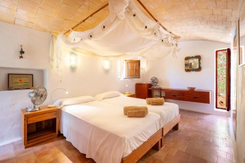 a bedroom with a large white bed in a room at Sa Paret Nova in Sant Francesc Xavier