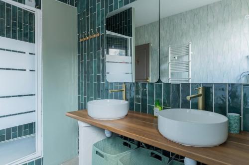 a bathroom with two sinks on a wooden counter at La Pause Picarde - Baie De Somme 1 in Franleu