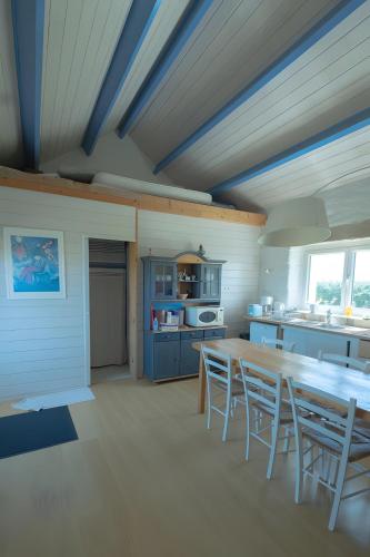 a kitchen with a long wooden table and chairs at L'ancien Gonio de l'Île in Lampaul