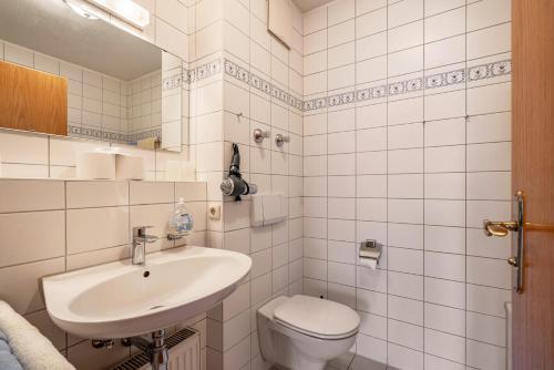 a white bathroom with a toilet and a sink at Fewo Brünnstein - Nr 11 Pool, Sauna in Oberaudorf