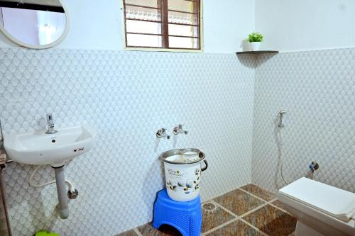 a bathroom with a sink and a toilet and a sink at Coffee Crown Homestay - 1km to Falls, Estate, Home Food in Sakleshpur
