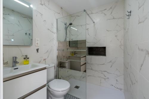 a white bathroom with a toilet and a sink at Loft A'ca La Puri en Melegís in Melegis