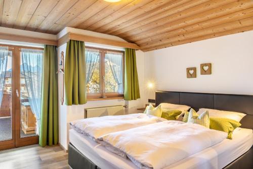 a bedroom with a large bed with green curtains at Ferienwohnungen Arnspitz in Krün in Krün
