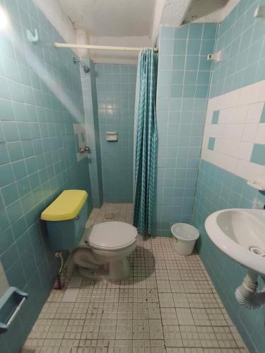 a blue bathroom with a toilet and a sink at Hotel Casa Lucina in Zihuatanejo