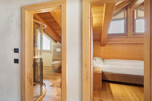 a small room with a bed and a shower at Livigno Wooden House in Livigno