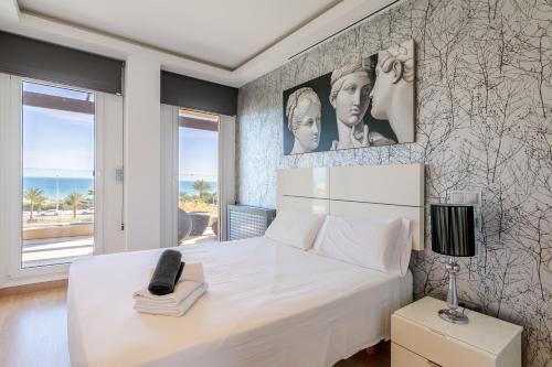 a bedroom with a large white bed and a window at Mediterranean Beach in Arenales del Sol