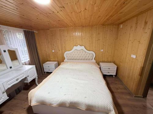 a bedroom with a bed and a vanity and a mirror at Ortabatumis house in Ch'aisubani
