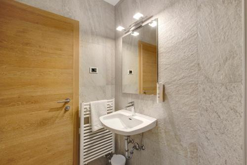 a bathroom with a sink and a mirror at Premium App Hofer Elisabeth in Villabassa