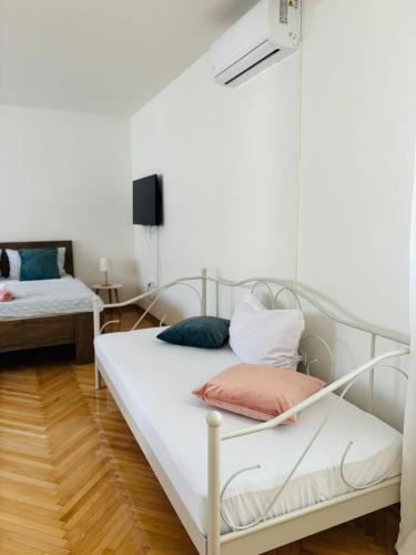 two beds in a room with white walls at Apartment Oak Root in Mostar