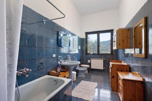 a bathroom with a tub and a sink and a toilet at Alta Via Ligure - La Squazza in Bertigaro