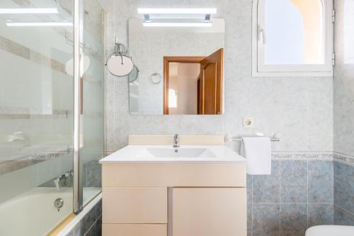 a white bathroom with a sink and a mirror at Villa Gaviota in Muro