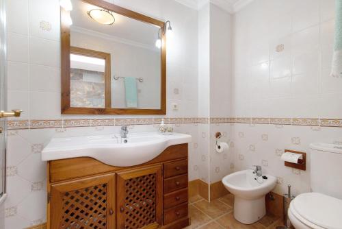 a bathroom with a sink and a toilet and a mirror at Casa La Herradura in Telde