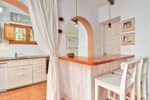 a kitchen with white cabinets and a wooden counter top at Casa Oliana in Cómpeta