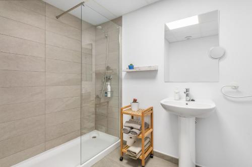 a white bathroom with a shower and a sink at Lopimar Playa in Canet de Berenguer