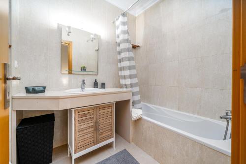 a bathroom with a sink and a bath tub at Aqua Studio in Portimão
