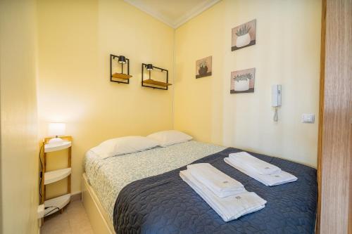 a bedroom with a bed with two towels on it at Aqua Studio in Portimão