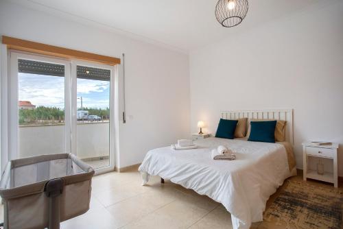 a white bedroom with a bed and a large window at A O - Tina House Ferrel in Ferrel