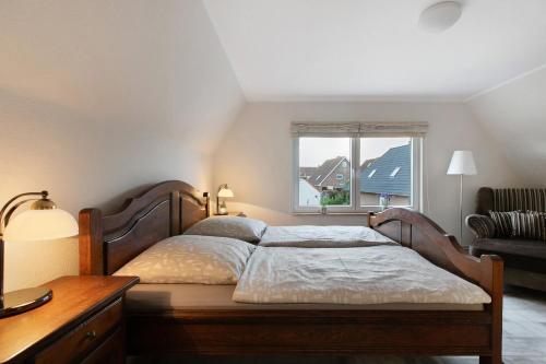 a bedroom with a large bed and a window at Ferienwohnung Janina in Norddeich