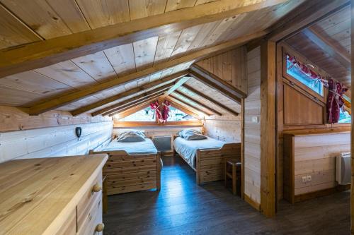 a room with two beds in a cabin at Chalet La Petite Maison in Saint-Marcel