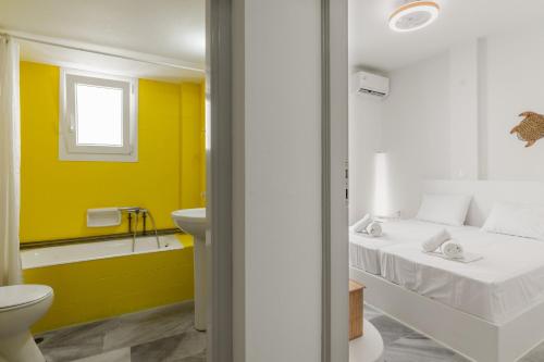 a bathroom with a bed and a tub and a sink at A Tinian Room 3 in Tinos