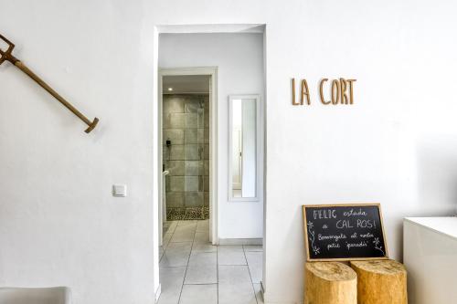 a white hallway with a chalkboard on the wall at Masia Cal Ros in S'agaro