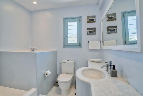 a white bathroom with a sink and a toilet at Villa Afroditi A in Antiparos