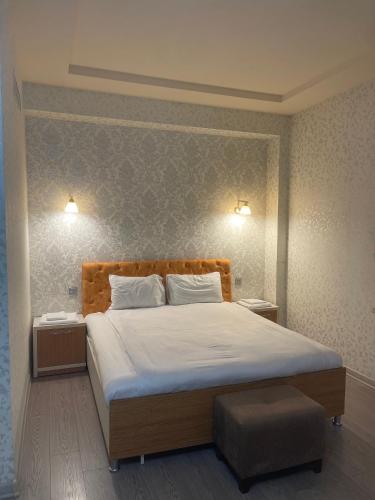 a bedroom with a large bed and two night stands at Cirag Hotel Kurdemir in Kyurdamir