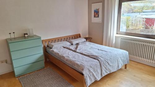 a bedroom with a bed and a dresser and a window at Ferienwohnung im Molsbachtal, 1,5 km zum Stausee in Happurg