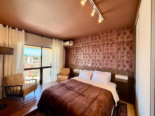 a bedroom with a large bed and a large window at Central Duplex Loft Near USP in São Carlos