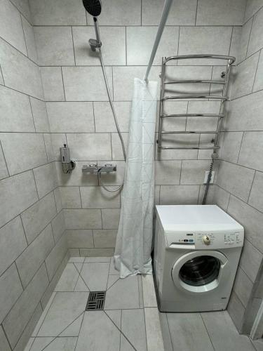 a shower with a washing machine in a bathroom at NV Apartments in Volodymyr-Volynskyi