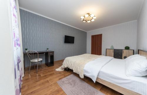 a bedroom with a bed and a desk and a television at Apartment near VDNG 18010 in Kyiv