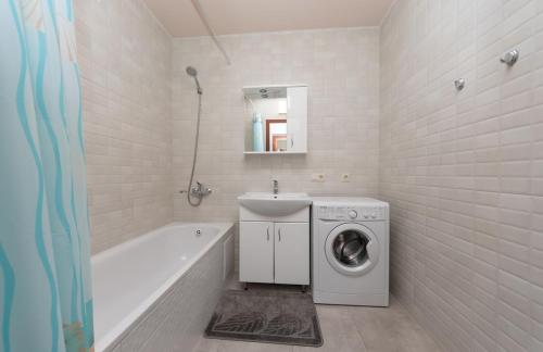 a bathroom with a washing machine and a bath tub at Apartment near VDNG 18010 in Kyiv