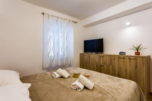 a bedroom with a bed with two towels on it at Kuća Ružica in Omiš