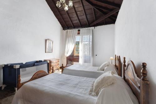 a bedroom with two beds and a chandelier at Casa Rural El Palmar in Vallehermoso