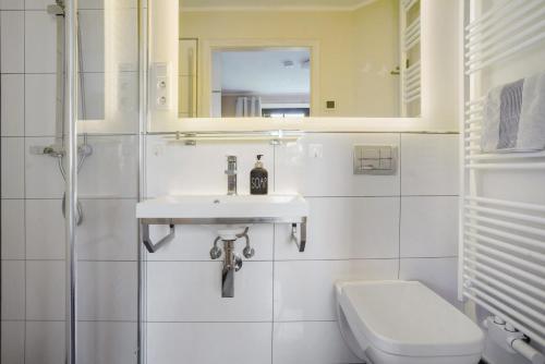 a bathroom with a sink and a toilet and a mirror at Ferienwohnung Sonnenblick in Putbus