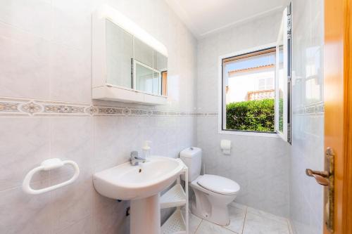 a white bathroom with a sink and a toilet at Villa Sion in Cala Mendia