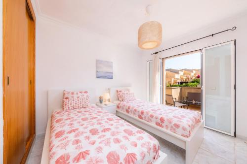 a bedroom with two beds and a large window at Villa Sion in Cala Mendia
