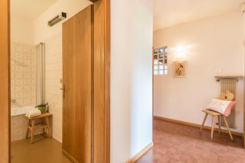 a hallway with a door and a chair in a room at Ferienwohnung 3 Vikoler in Vols am Schlern