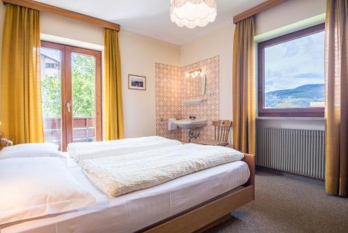 a bedroom with a bed and a sink and a window at Ferienwohnung 3 Vikoler in Vols am Schlern
