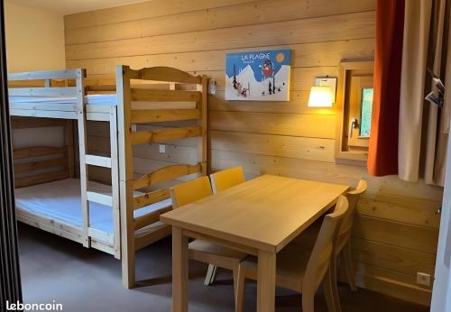 a dining room with a table and a bunk bed at Appartement Soldanelle in La Plagne Tarentaise