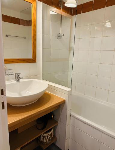 a white bathroom with a sink and a shower at Appartement Soldanelle in La Plagne Tarentaise
