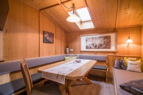 a dining room with a wooden table and benches at Ferienhaus Waidmannsruh in Hippach