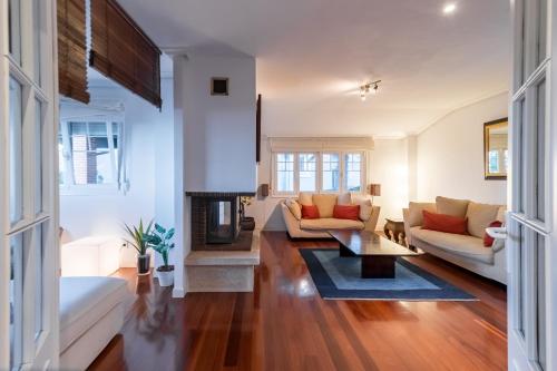 a living room with a couch and a fireplace at Villa La Perla De Sonabia in Oriñón