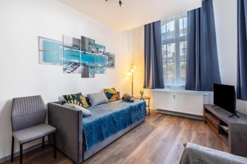 a living room with a bed and a television at murihaus Ferienwohnung 2 in Aue
