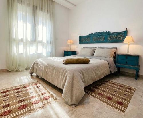 a bedroom with a large bed with a blue headboard at Studio Al Wahat in Douar el Hafey