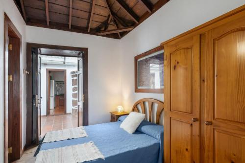 ein Schlafzimmer mit einem blauen Bett und einem Holzschrank in der Unterkunft Casa El Café in Las Tricias