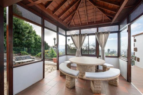 ein Esszimmer mit Tisch, Stühlen und Fenstern in der Unterkunft Casa El Café in Las Tricias