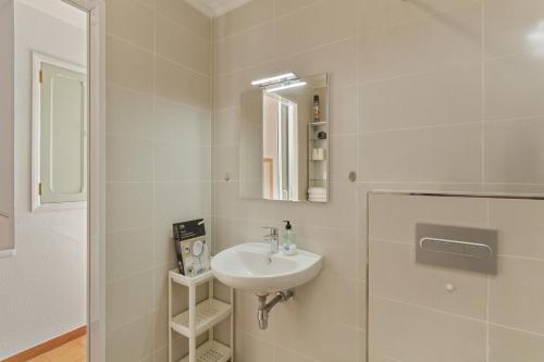 a white bathroom with a sink and a mirror at Casa Carmelo in Patalavaca
