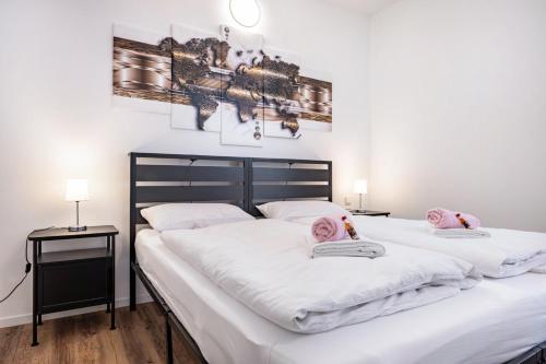 a bedroom with two beds with white sheets and pink pillows at Die Alter Schwede Wohnung 1 in Vechta
